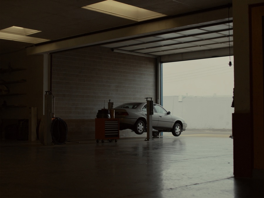 A car raised on a lift in a repair bay