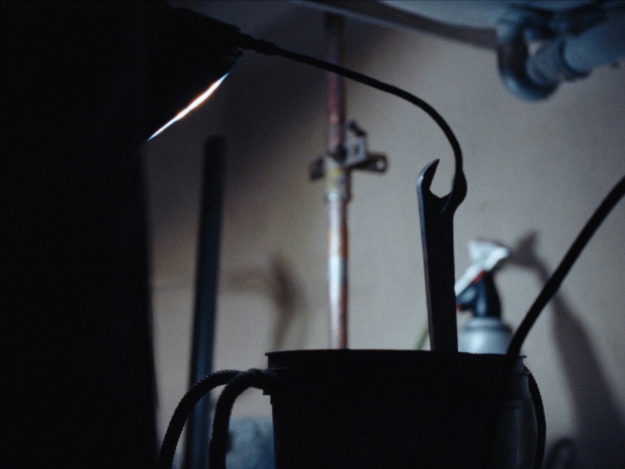 A work light on copper pipes under a kitchen sink
